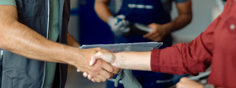 Smiling mechanic helping a customer